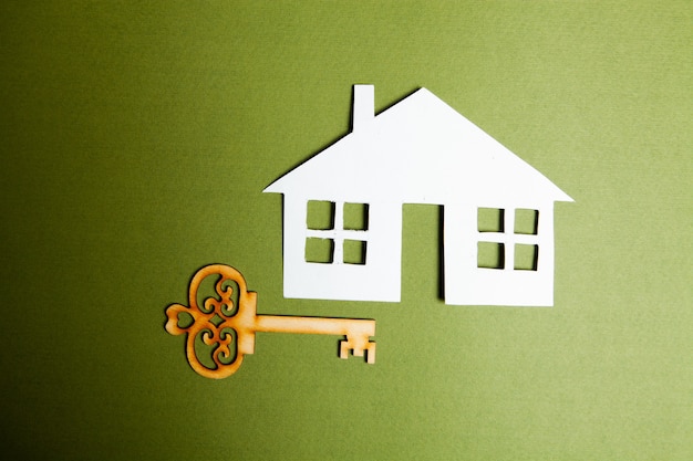Schlüssel und Haus auf grünem Hintergrund