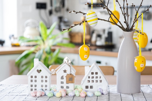 Schlüssel zum Haus des gemütlichen Hauses mit Osterdekor mit Hasen und Eiern auf dem Tisch der Küche Gebäudedesignprojekt Umzug in neue Haushypothekenversicherung Miete und Kauf von Immobilien