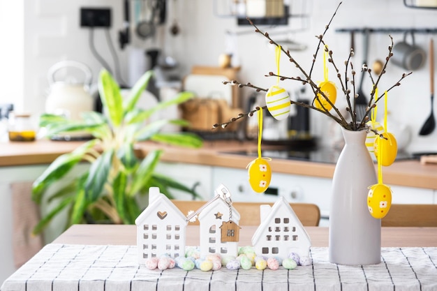 Schlüssel zum Haus des gemütlichen Hauses mit Osterdekor mit Hasen und Eiern auf dem Tisch der Küche Gebäudedesignprojekt Umzug in neue Haushypothekenversicherung Miete und Kauf von Immobilien