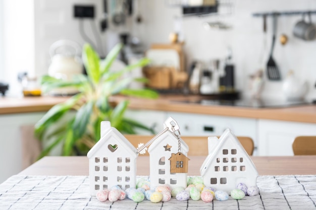 Schlüssel zum Haus des gemütlichen Hauses mit Osterdekor mit Hasen und Eiern auf dem Tisch der Küche Gebäudedesignprojekt Umzug in neue Haushypothekenversicherung Miete und Kauf von Immobilien