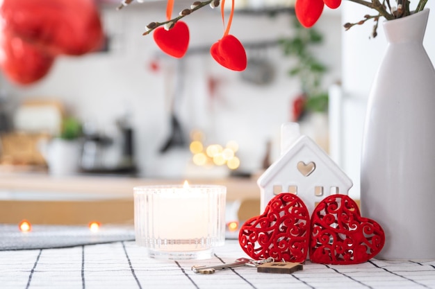 Schlüssel zum Haus des gemütlichen Zuhauses mit Valentinsdekor auf dem Küchentisch Geschenk für den Valentinstag Familienliebesnest Bauprojekt Umzug in ein neues Haus Hypothek Miete und Kauf von Immobilien