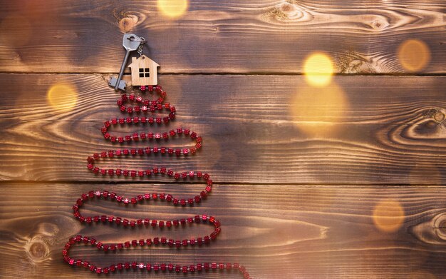 Schlüssel zum Haus mit einem Schlüsselbund auf dem Weihnachtsbaum aus roten quadratischen Perlen