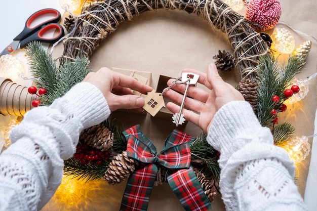 Schlüssel zum Haus mit Schlüsselanhänger auf gemütlichem Zuhause in Geschenkbox mit Weihnachtsdekorverpackung Pack vorhanden für Neujahr Weihnachten Bauprojekt Umzug in neues Haus Hypothek Mietkauf Immobilien