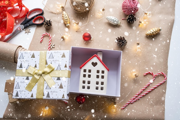 Schlüssel zum Haus mit Schlüsselanhänger auf gemütlichem Zuhause in Geschenkbox mit Weihnachtsdekorverpackung Pack vorhanden für Neujahr Weihnachten Bauprojekt Umzug in neues Haus Hypothek Mietkauf Immobilien