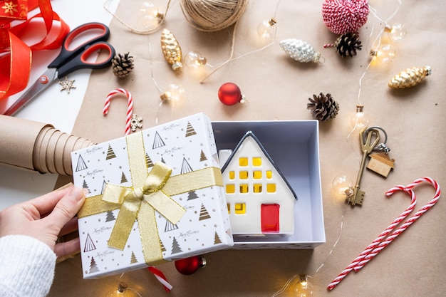 Schlüssel zum Haus mit Schlüsselanhänger auf gemütlichem Zuhause in Geschenkbox mit Weihnachtsdekorverpackung Pack vorhanden für Neujahr Weihnachten Bauprojekt Umzug in neues Haus Hypothek Mietkauf Immobilien