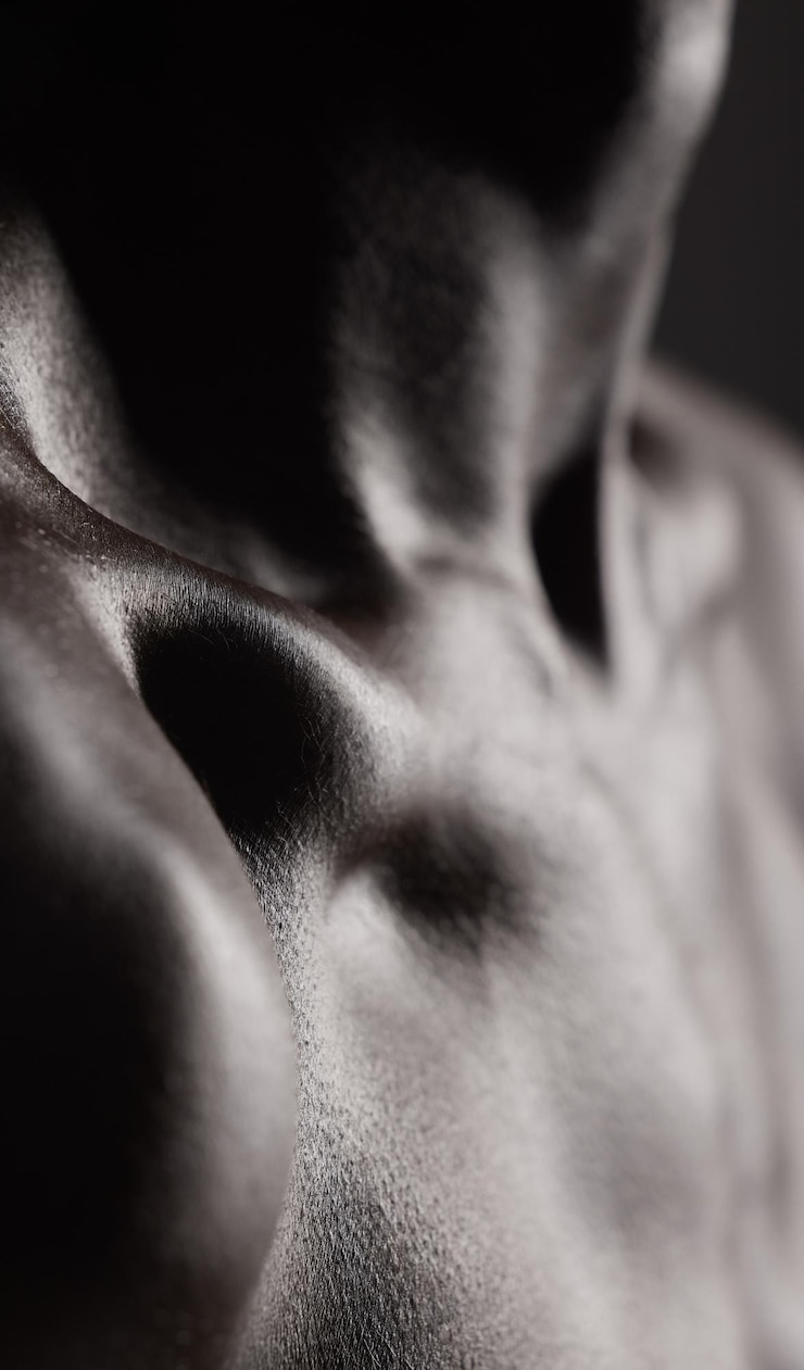 Foto schlüsselbein-nahaufnahme und haut oder körper eines mannes mit muskeln und kosmetischer gesundheit und modell mit glanz aus der dermatologie. brustschulter und person mit wohlbefinden im dunklen studio oder schwarz-weiß-attrappe