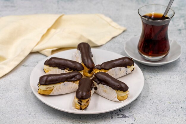 Foto schmackhafte eclairs und eine tasse tee auf einem steintisch traditionelles französisches dessert gebäckprodukte nahaufnahme