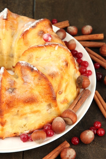 Schmackhafter hausgemachter Kuchen mit Beeren, Nüssen und Gewürzen auf einem Holztisch