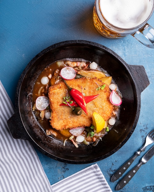 Schmackhaftes Hühnerschnitzel auf einer Pfanne. Ansicht von oben