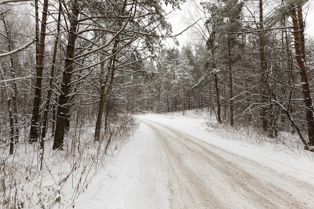 Schmale unbefestigte schneebedeckte Winterstraße für den Autoverkehr