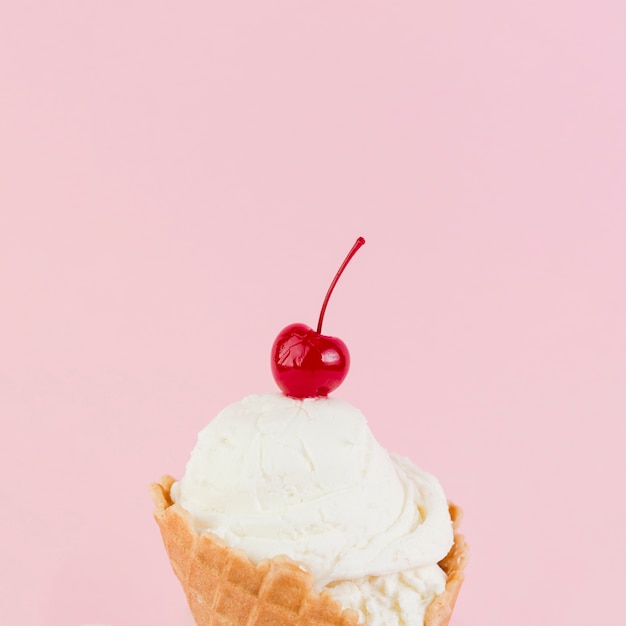 Schmelzende eiskugel mit kirsche oben im kegel