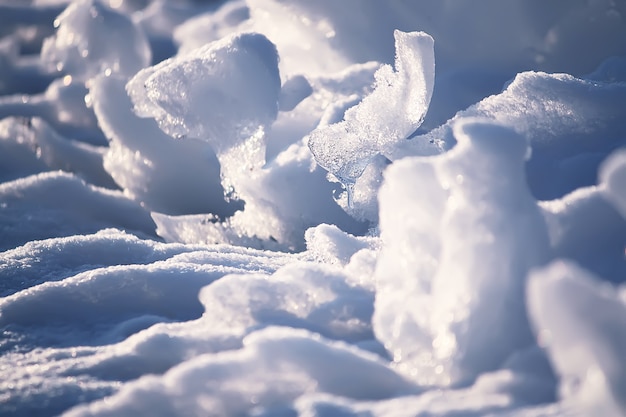 Schmelzende Schnee- und Eisoberfläche hautnah in der Abendsonne im Winter