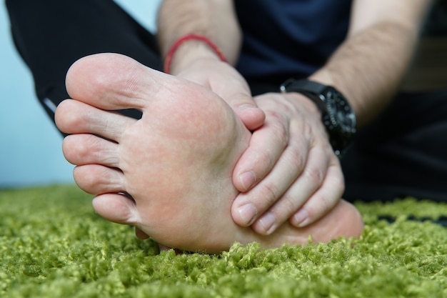 Schmerzen im fuß. Massage der männlichen Füße. Pediküre. gebrochener Fuß, ein wunder Fuß, massieren der Ferse.