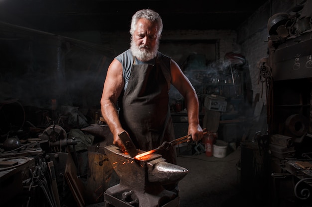 Schmied Handwerker in Schürze arbeitet in der Schmiede