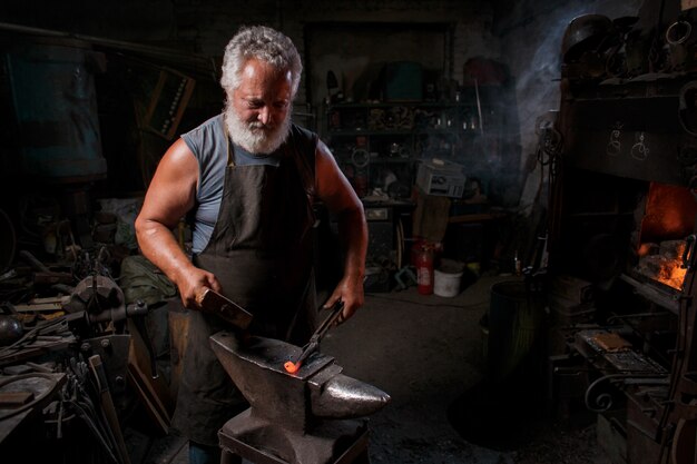 Schmied Handwerker in Schürze arbeitet in der Schmiede