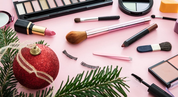 Schminken Sie Weihnachtskosmetikprodukte vor rosafarbenem Hintergrund