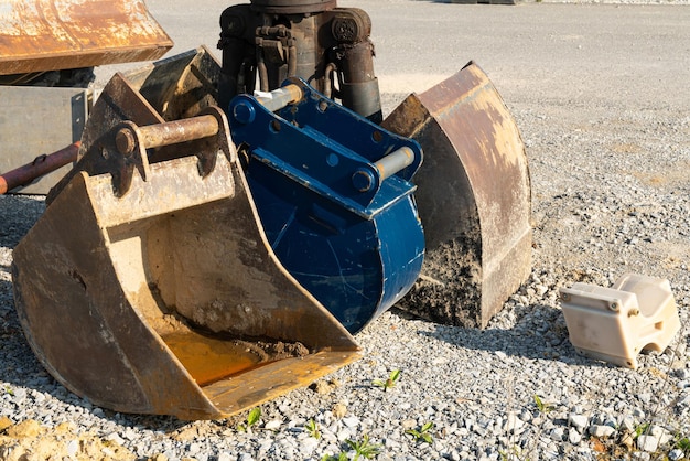 Schmutzige Baggerschaufeln stehen auf einer Baustelle