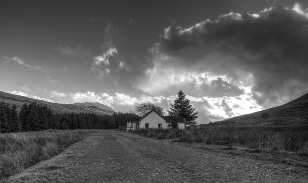 Schmutzige Straße durch Feld gegen den Himmel