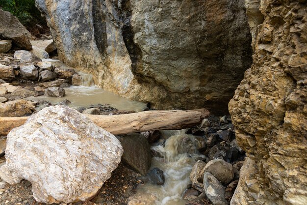 Schmutziger Gebirgsfluss nach Regen, zwischen wilden Felsen.