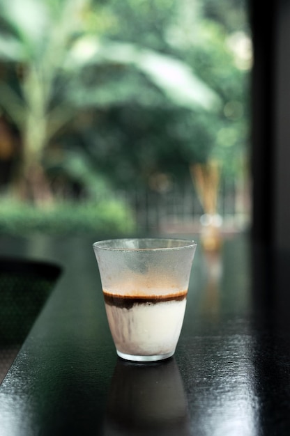 Schmutziger Kaffee - Ein Glas Espresso, gemischt mit kalter frischer Milch im Café und Restaurant des Cafés