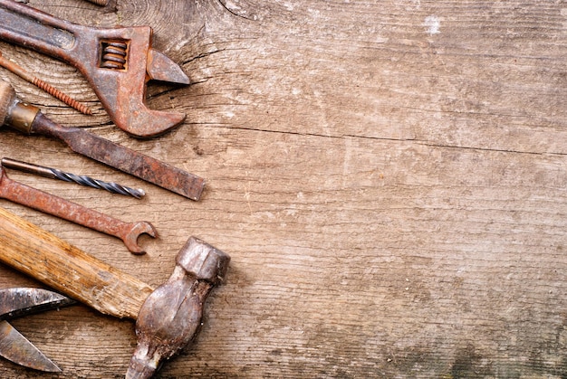 Schmutziger Satz Handwerkzeuge auf einem Vintage-Foto mit Holzhintergrund