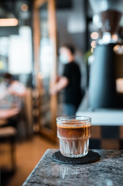 Schmutziges Kaffeeglas kalte Milch mit heißem Espresso-Kaffee-Shot