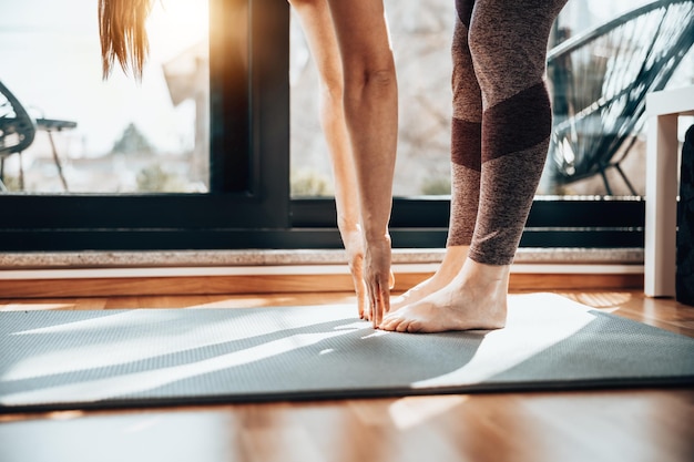 Schnappschuss einer entspannten jungen Frau, die morgens zu Hause Yoga-Dehnübungen macht.