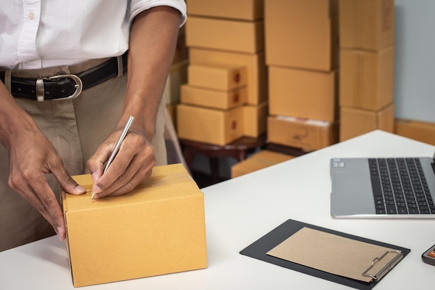 Schnappschuss eines Mannes, der ein Paket für die Lieferung in einem Online-Geschäftsbüro vorbereitet.