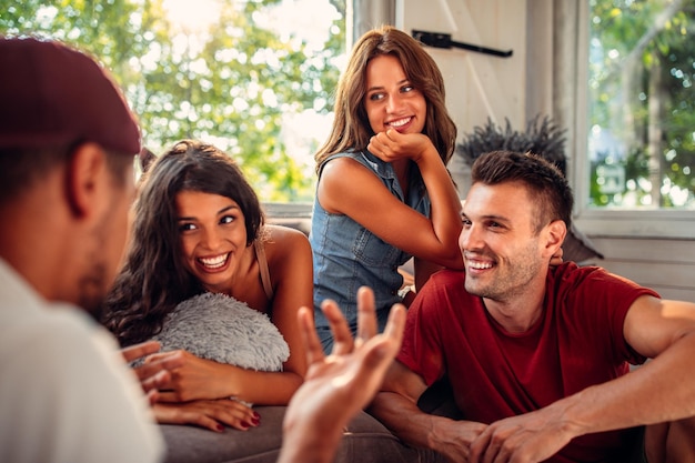 Schnappschuss von vier glücklichen Freunden, die im Wohnzimmer herumhängen