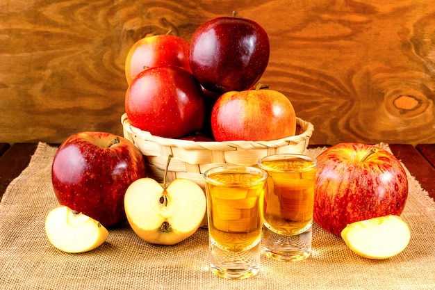 Schnapsgetränke und Äpfel im Weidenkorb