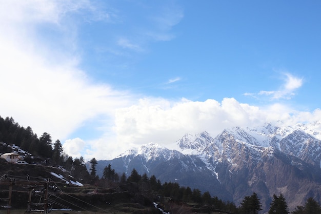 Foto schnee auf den berggipfeln und blauer himmel und baum in indien