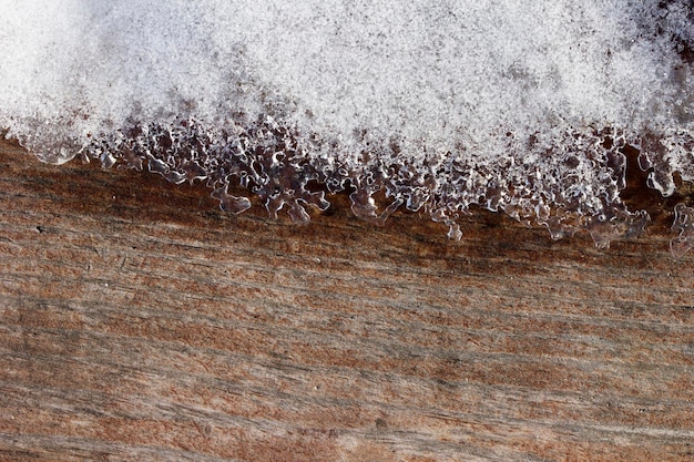 Schnee auf einem Stück Baum