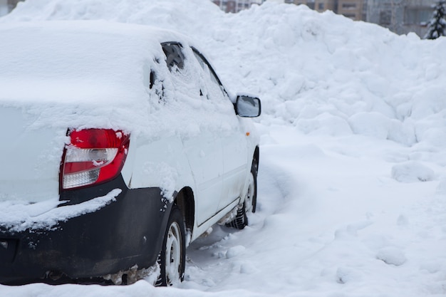 Schnee bedeckte nachts viele Autos auf der Straße in der Innenstadt