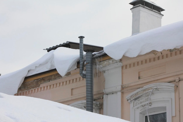 Schnee fällt vom Dach herab, Stadtlandschaft