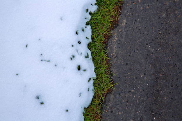 Schnee in der Straße mit Rasengraslinie