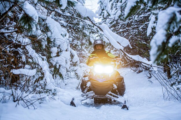 Schnee-Mobil-Scooter ATV-Fahrzeug Waldstraße arktische nordische Schnee-Schlittenverkehr Mann ist