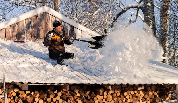 Schnee vom Dach säubern mit Schaufelmann in Aktion