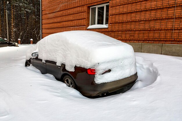 Schneebedeckte Autos im Hof des Hauses. Klima, Wetter.