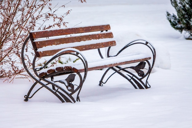 Schneebedeckte Bank im Stadtpark. Der erste Schnee_