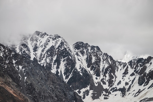 Schneebedeckte Berggipfel, die von Nebel bedeckt sind