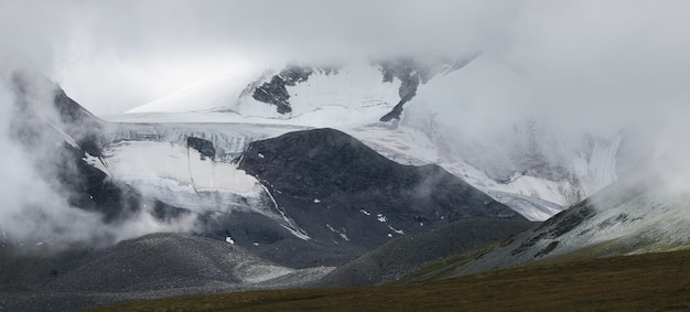 Schneebedeckte Berggipfel und Gletscher in den Wolken, Unwetter