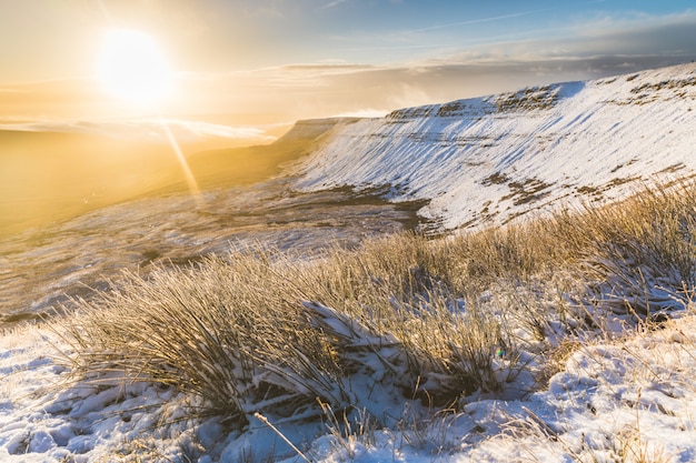 Schneebedeckte Landschaft des Winters bei Sonnenaufgang in Wales