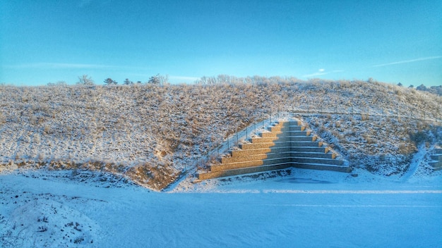 Foto schneebedeckte landschaft vor klarem blauen himmel