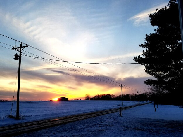 Foto schneebedeckte straße gegen den himmel beim sonnenuntergang