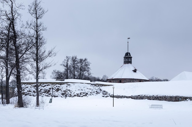 Schneebedeckte Winterlandschaft mit Steinmauer der alten Festung und niedrigem Rundturm Priozersk Russland