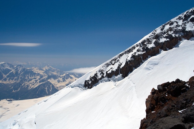 Schneebedeckter Berghang mit blauem Himmel im Hintergrund