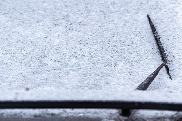 Schneebedecktes Autofenster mit Scheibenwischern