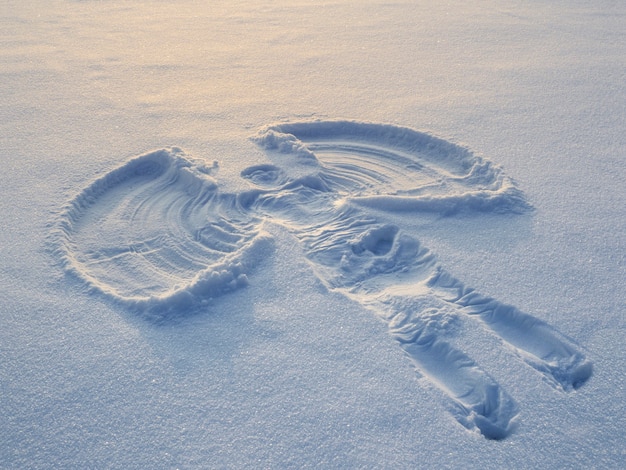 Schneeengel im weißen Schnee am Abend gemacht. Draufsicht.