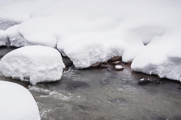 Schneefall auf dem Fluss. Schöne Winterlandschaft.