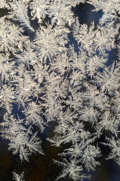 Schneeflocken, Frost, Rime, Makro auf der Fensterglasscheibe, farbenfrohes Eis auf der Fenstergelände, natürlich.